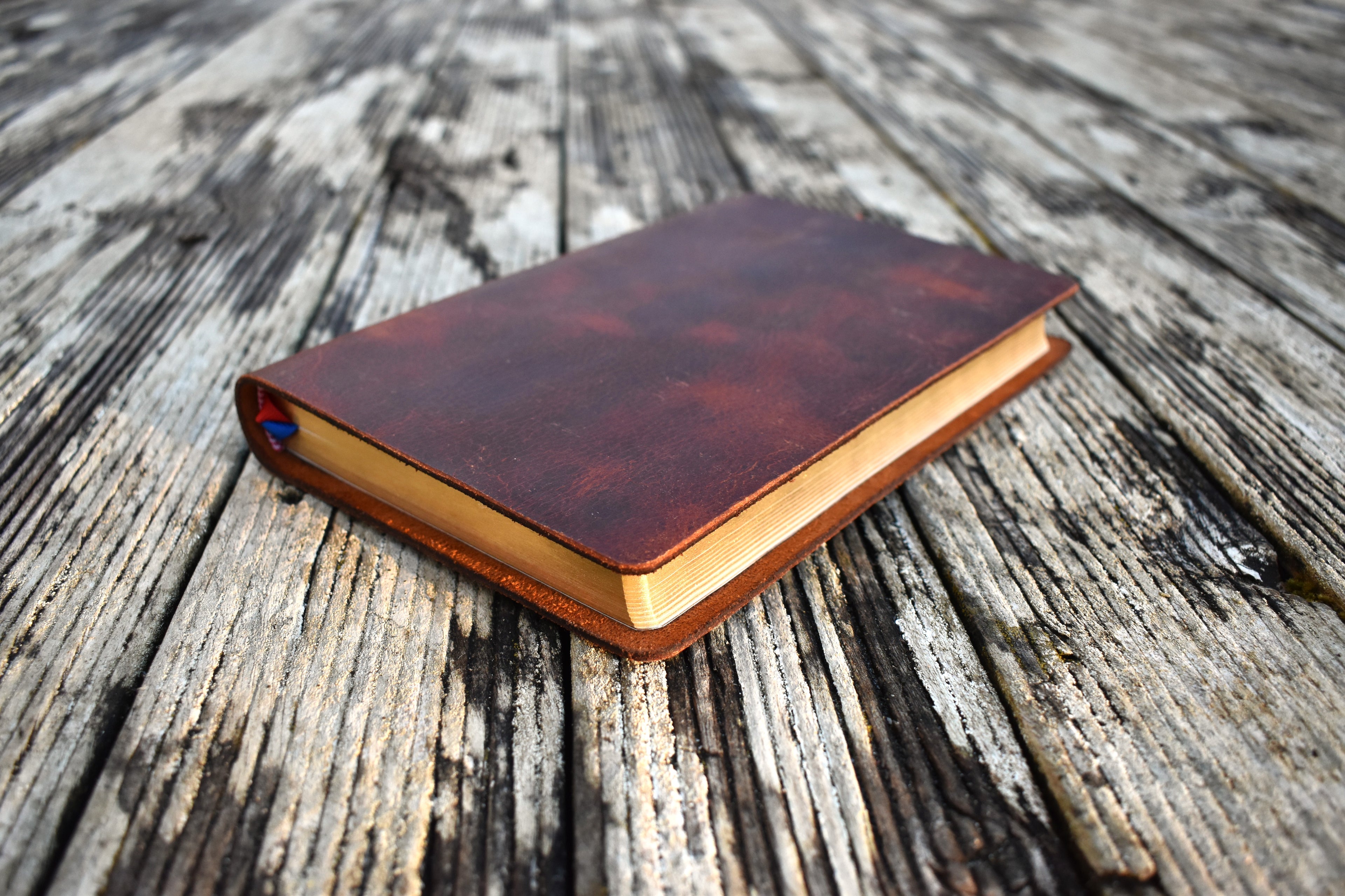 Leather bible handbound in NZ, laying on a deck
